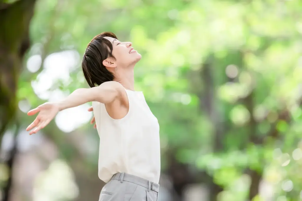 自然の中で伸びをする女性