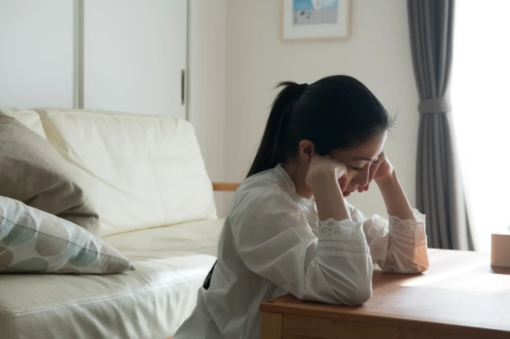 自室で悩んでいる女性