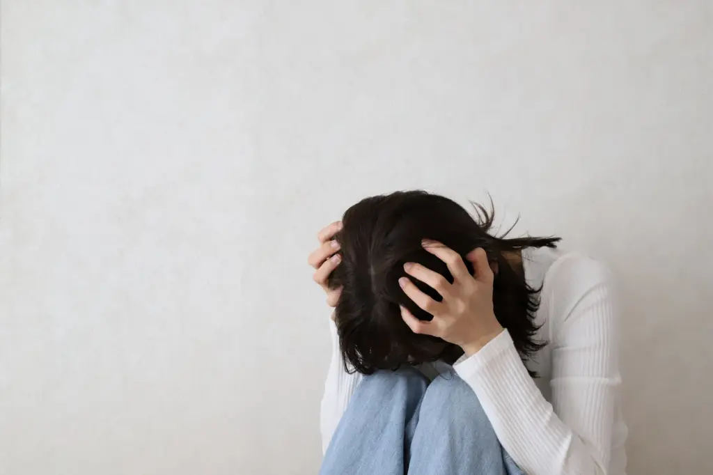 頭を抱えて悩む女性