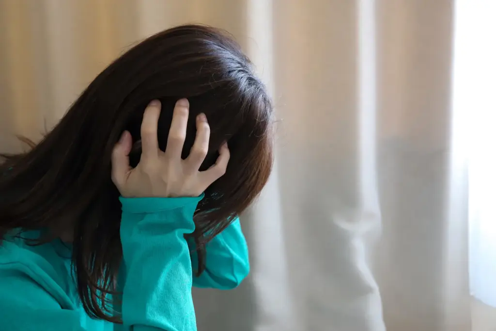 頭を抱えて悩む女性