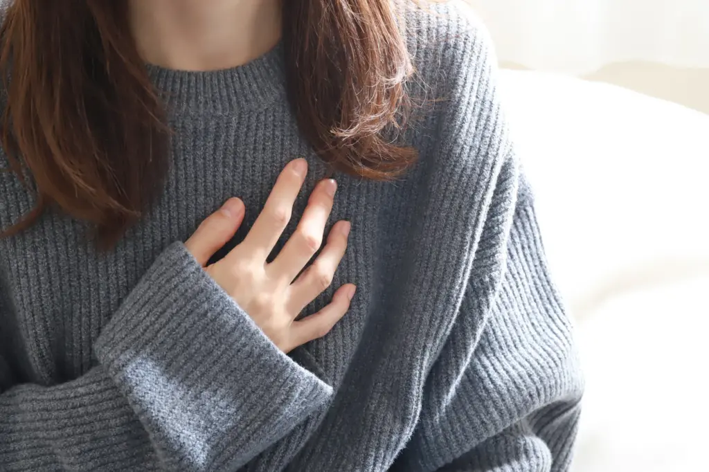 胸に手を当てる女性