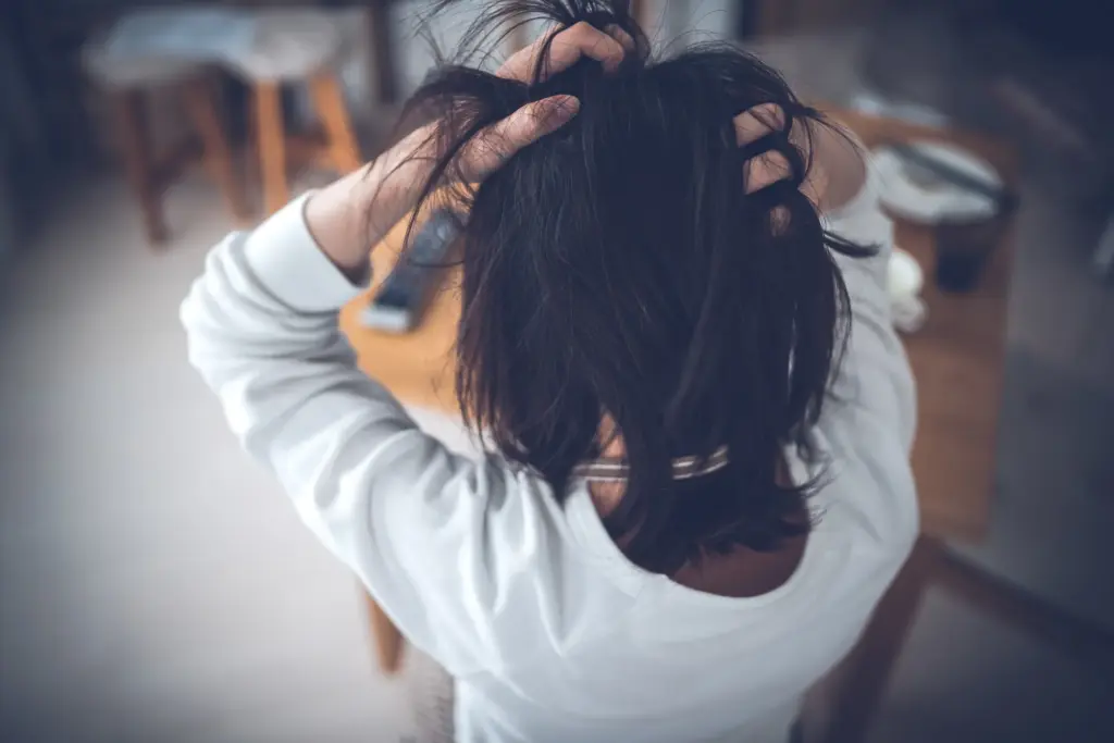 頭を掻きむしっている女性