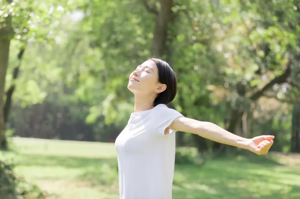 自然の中で伸びをしている女性