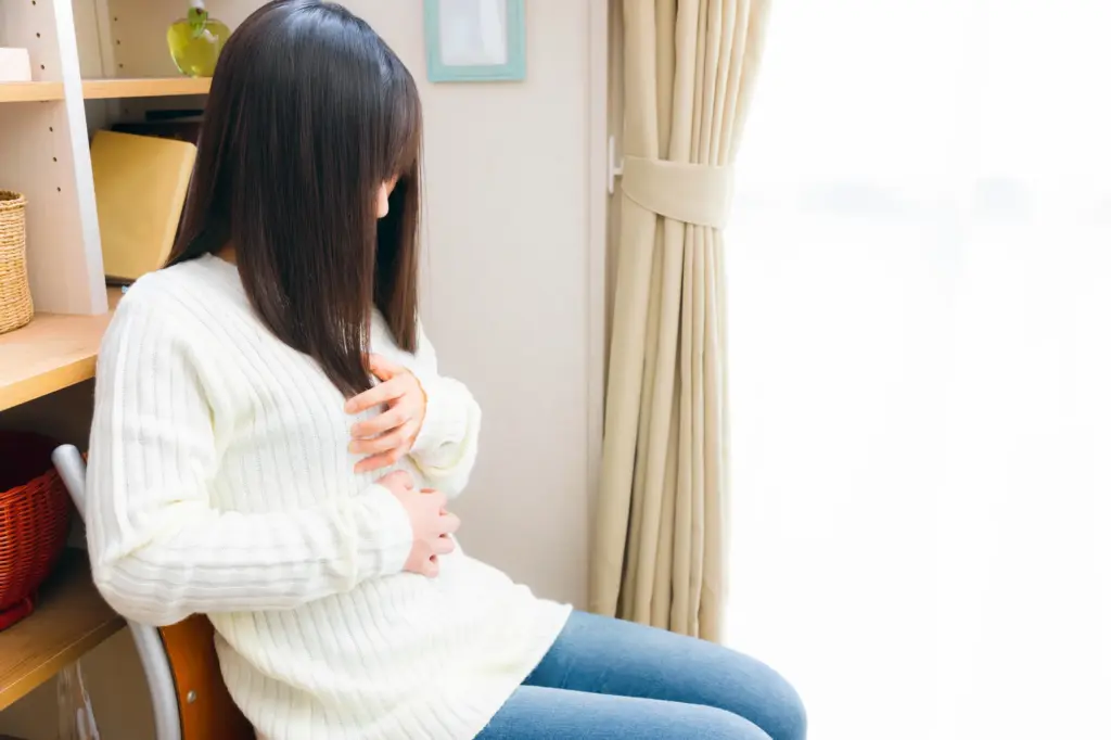 胸を抑える女性
