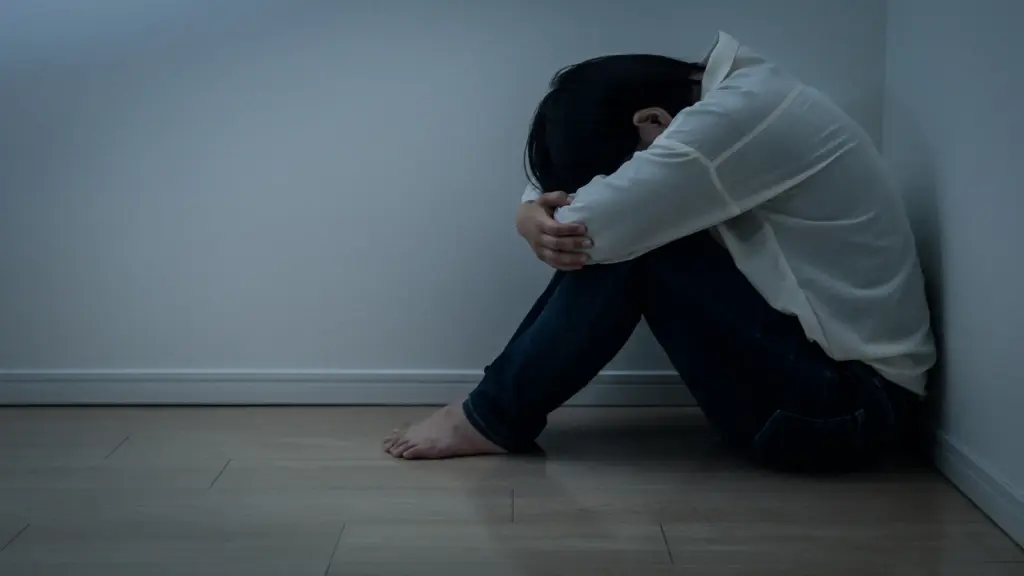 膝をかかえてふさぎ込む男性