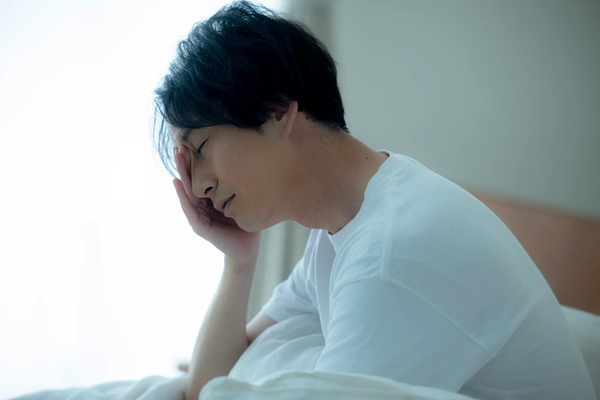 目覚めが悪く悩む男性