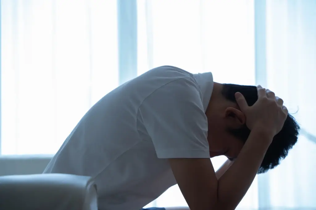 頭を抱えて悩む男性