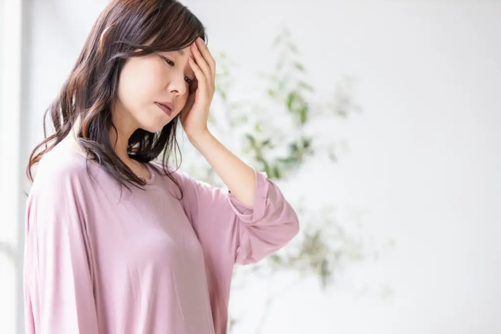 頭を押さえた女性