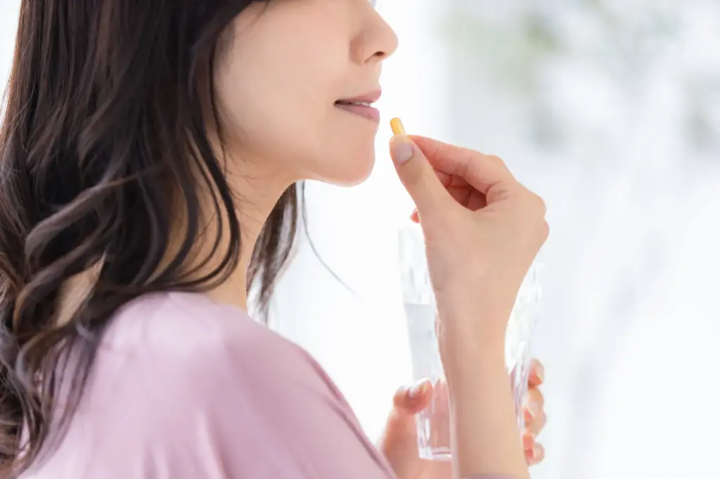 薬を飲む女性