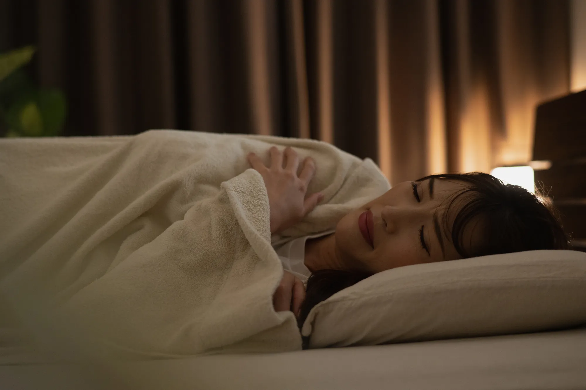 毛布をかぶりぐっすり眠る女性